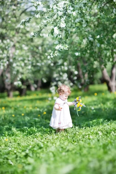 Güzel küçük bir kız çiçekleri ile oynama — Stok fotoğraf