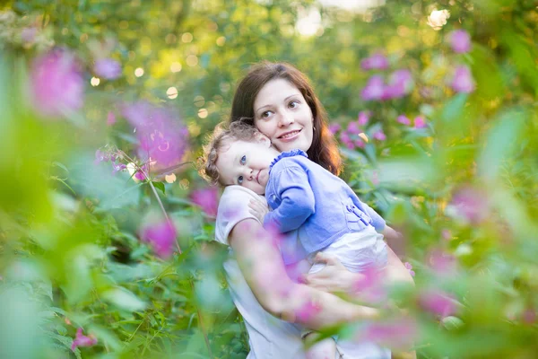 Yorgun bebek kızı parkta tutan anne — Stok fotoğraf