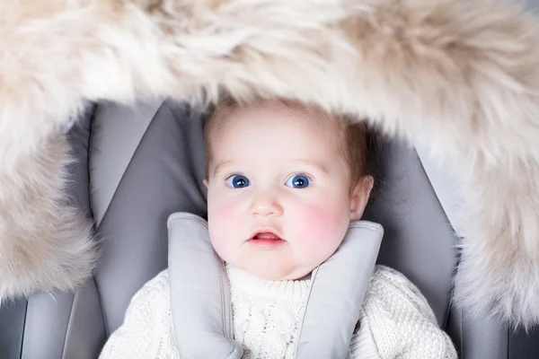 Little baby sitting in a warm stroller — Stock Photo, Image