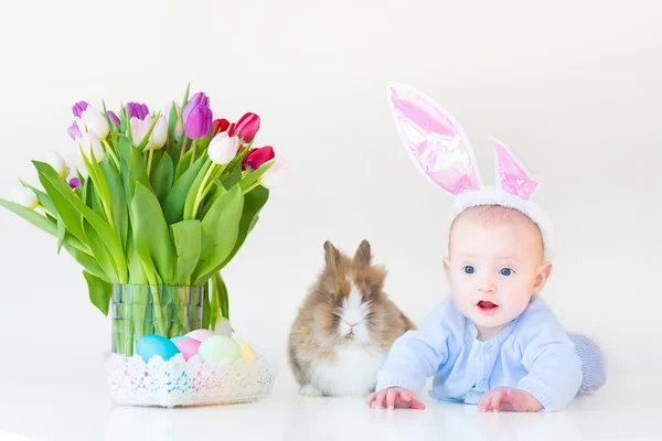 Menino com orelhas de coelho brincando com um coelho real — Fotografia de Stock