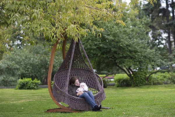 Moeder en haar baby dochter in een hangmat — Stockfoto