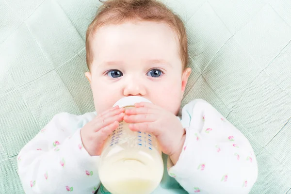 Baby girl with a milk bottle — Stock Photo, Image