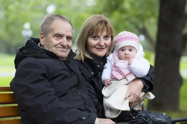 Velký dědeček, babička a malá holčička v parku — Stock fotografie