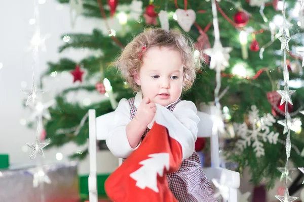 Toddler girl checking her Christmas stocking — Stock Photo, Image