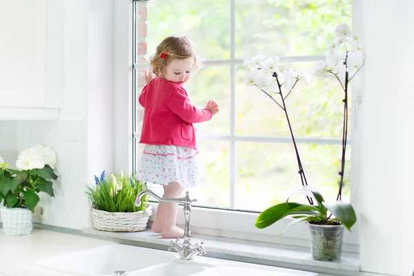 Ragazza bambino guardando fuori da una finestra — Foto Stock