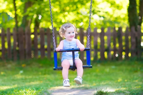 Glad skrattande småbarn girlenjoying swing skjuts — Stockfoto