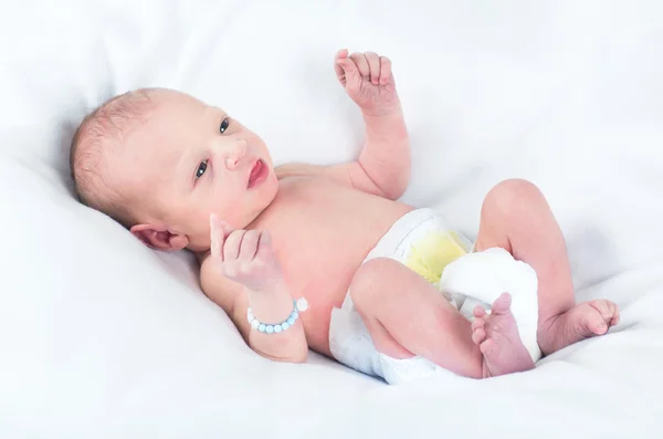 Bebê recém-nascido relaxando em um cobertor branco — Fotografia de Stock