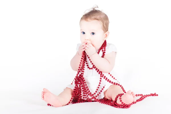 Bambino ragazza che gioca con la collana rossa — Foto Stock