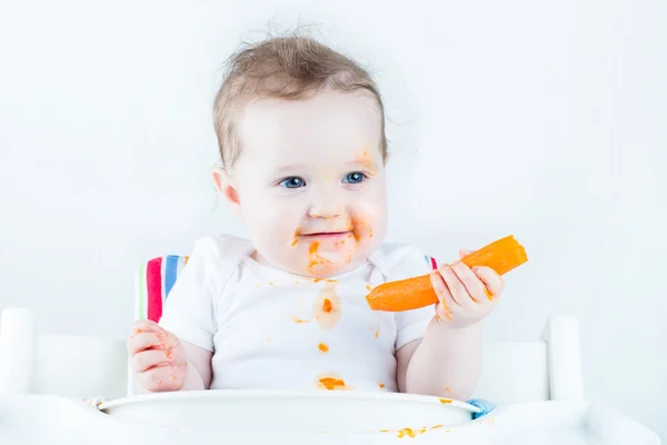 Doce bebê comendo cenoura — Fotografia de Stock
