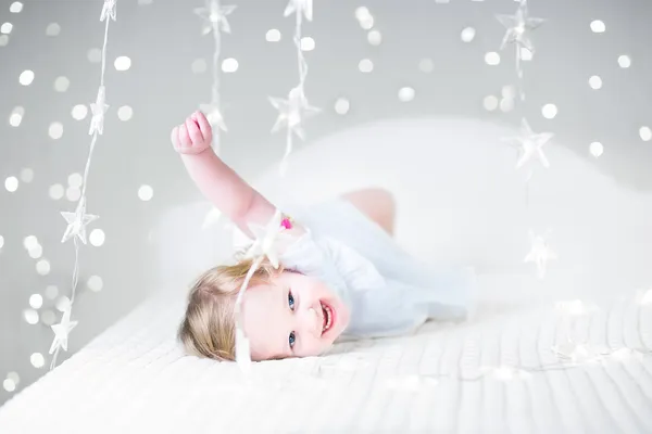 Peuter meisje spelen in een witte bed — Stockfoto