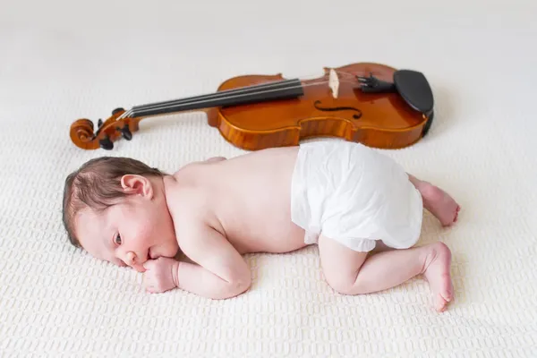 Novorozená dívka ležící vedle housle — Stock fotografie