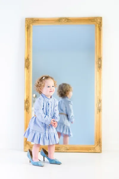 Girl standing in front of a big mirror — Stock Photo, Image