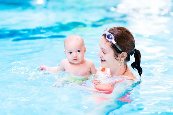 Niño disfrutando de clases de natación en la piscina con su madre —  Fotos de Stock