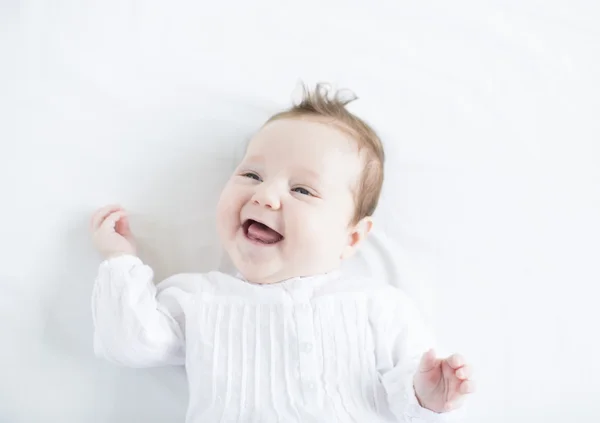 Baba lány nevetve fogatlan fehér ruhát — Stock Fotó