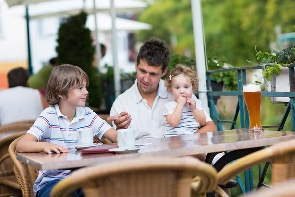 Young father enjoying a meal with his son and baby daughter — Stock Photo, Image