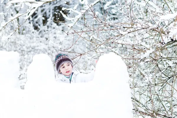 Pojke spelar i ett snö fort — Stockfoto