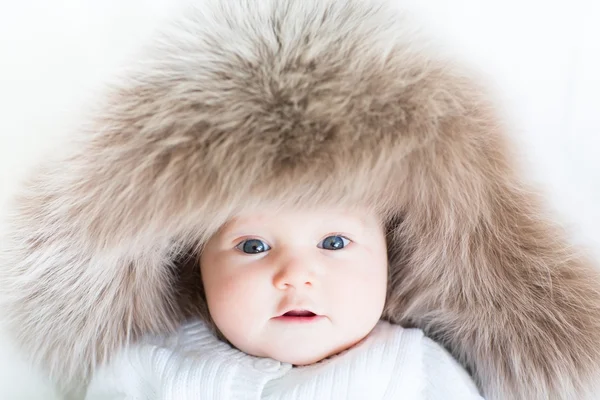 Baby wearing a big fur hat — Stock Photo, Image