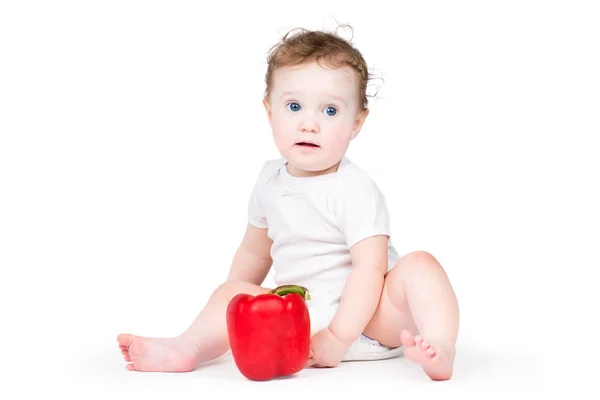 Baby playing with a red paprika — Stock Photo, Image