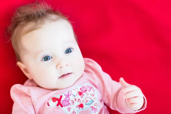 Baby girl on a red blanket — Stock Photo, Image