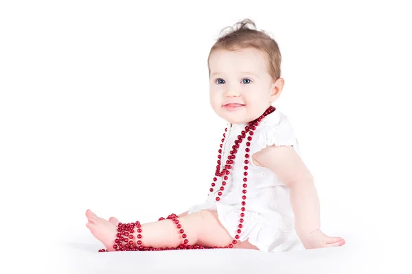 Baby girl playing with red pearls — Stock Photo, Image
