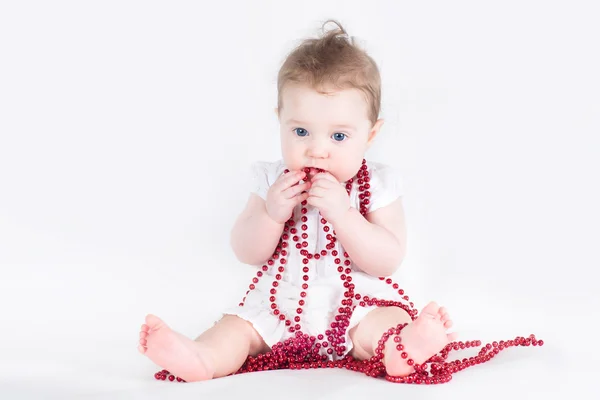 Mignon bébé fille jouer avec collier rouge — Photo