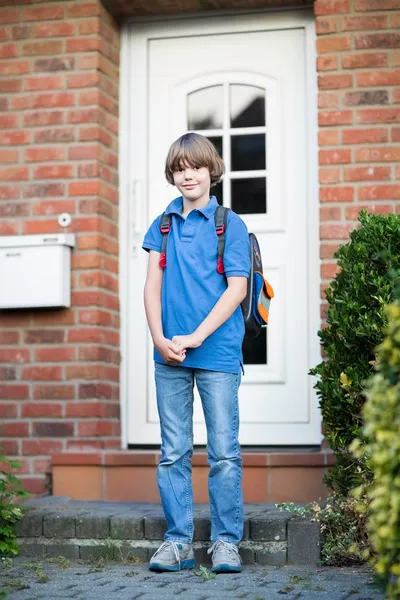Мальчик уходит из дома по пути в первый день в школу — стоковое фото