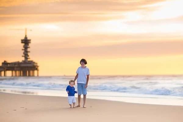 Broer en zus spelen op een mooi strand — Stockfoto