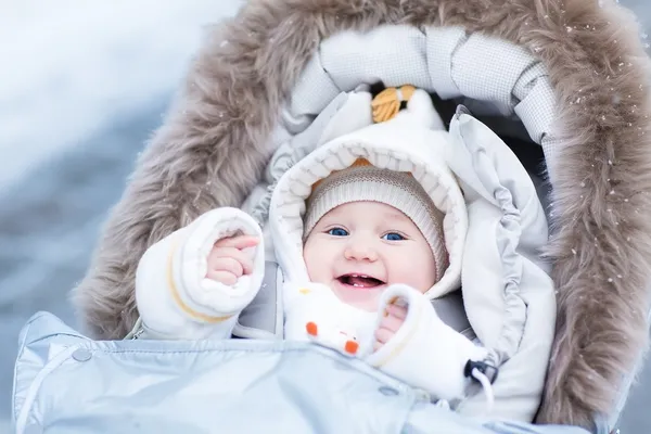 Meisje van de baby genieten van een wandeling in een besneeuwde winter park — Stockfoto