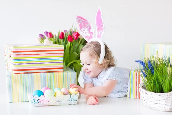 Maluch dziewczyna z uszy królika, grając z Wielkanoc prezenty — Zdjęcie stockowe