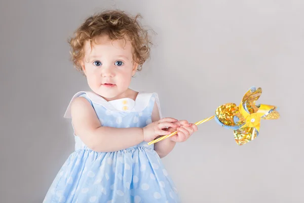 Babymeisje met een wind-speelgoed — Stockfoto
