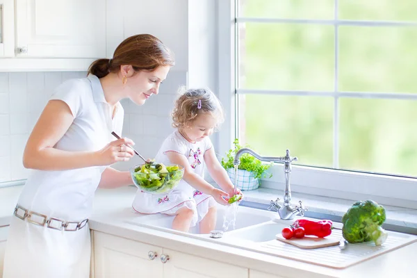 Mor och hennes dotter tvätta grönsaker — Stockfoto