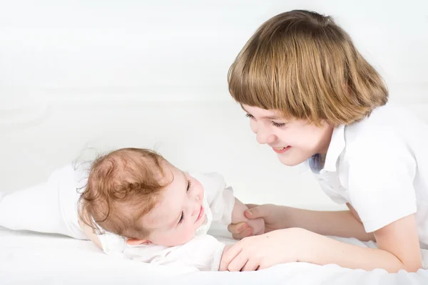 Meisje van de baby spelen met haar broer — Stockfoto