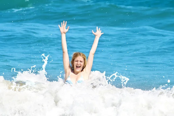 Mladá žena skákání ve vlnách — Stock fotografie