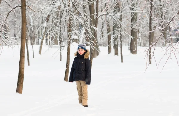 Karlı bir parkta yürüyen çocuk — Stok fotoğraf