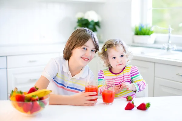 Tiener jongen en zijn zus gelet fruit en granen met aardbei voor het ontbijt — Stockfoto