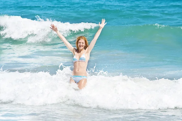 Junge Frau springt in die Wellen — Stockfoto
