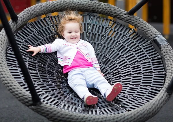 Bebê menina relaxante em um balanço — Fotografia de Stock