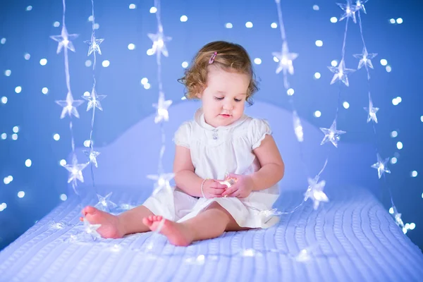 幼児の女の子の白いベッドの上再生 — ストック写真