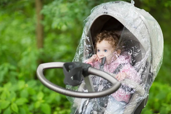 Baby flicka sitter i en barnvagn — Stockfoto