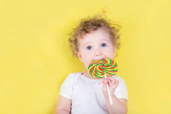 Baby girl with a big candy — Stock Photo, Image