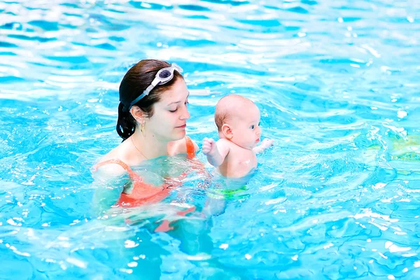 Jonge moeder en baby zoon in een zwembad — Stockfoto