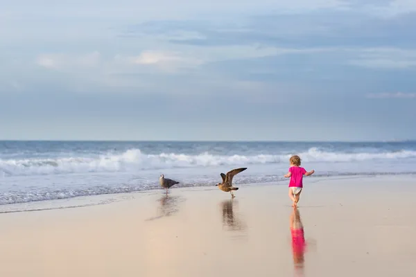 Bebê menina correndo na praia — Fotografia de Stock