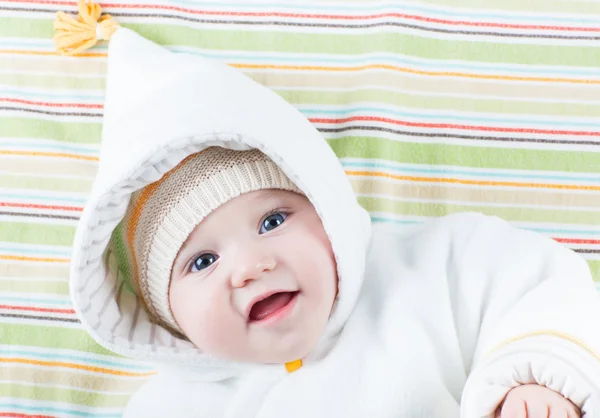 Linda niña riendo divertida relajándose en una manta colorida — Foto de Stock