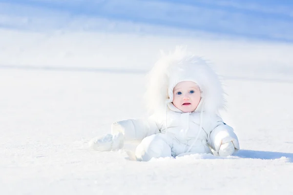 Pequena menina sentada na neve branca — Fotografia de Stock