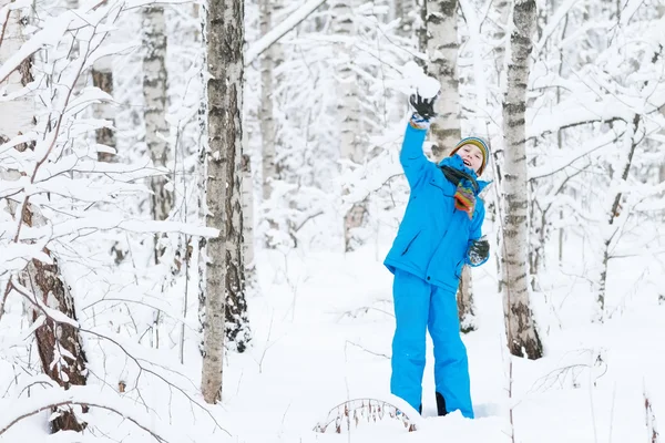 Lindo chico caminando en un bosque nevado —  Fotos de Stock