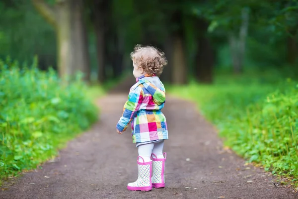 Söt lockigt baby flicka i en park — Stockfoto