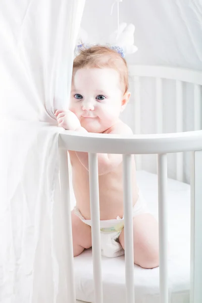 Engraçado bebê brincando em seu berço — Fotografia de Stock