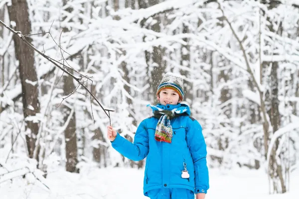 Garçon jouer avec la neige dans un parc d'hiver — Photo