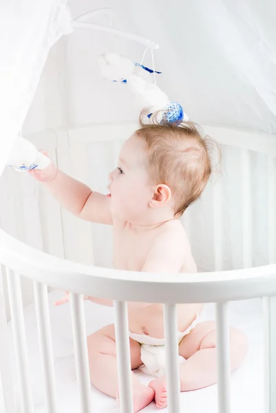 Funny baby  playing in its crib — Stock Photo, Image