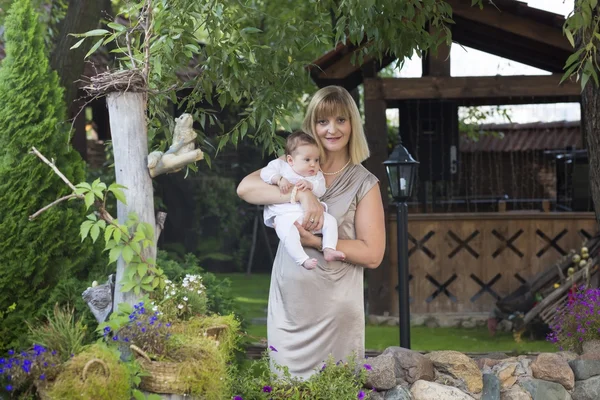 Elegant lady holding a baby on the stairs — Stock Photo, Image